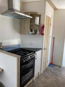 a kitchen with a stove top oven in a room at Faville in Selsey