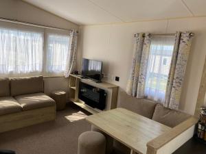 a living room with a couch and a table at Faville in Selsey +1 photo