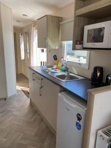 a kitchen with a sink and a microwave at Faville in Selsey
