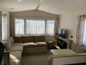 a living room with a couch and a tv at Faville in Selsey