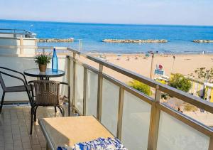a balcony with a table and a view of a beach at Terrazzo Panoramico Fronte Mare Zamponi in Civitanova Marche