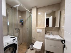 a bathroom with a washing machine and a sink at Marea Apartment in Bar +15 photos