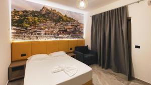 a bedroom with a bed with a painting on the wall at Hotel Ruko Boutique Deluxe in Golem +89 photos
