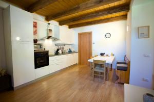 a kitchen with white cabinets and a table at Casa Azzurra - Spacious apartment in the heart of Julian Alps in Cave del Predil