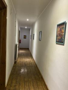 a long hallway with a wooden floor and paintings on the walls at Hafen12 in Bremerhaven