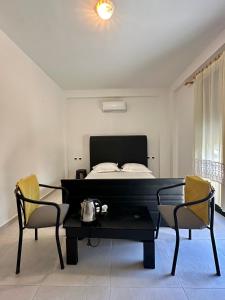 a bedroom with a bed and a table and chairs at Actium in Vlorë
