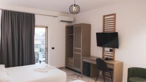 a hotel room with a bed and a desk and a television at Hotel Ruko Boutique Deluxe in Golem