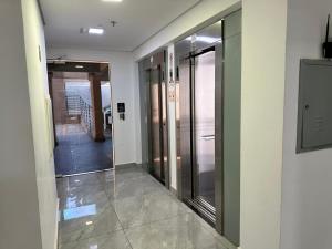 an empty hallway with glass doors in a building at Apartamento 83 - Carmelo in Ribeirão Preto