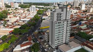 an aerial view of a city with a tall building at Apartamento 83 - Carmelo in Ribeirão Preto