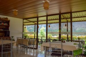 a restaurant with tables and chairs and large windows at Posada Tierra Viva - Villa de Leyva in Villa de Leyva