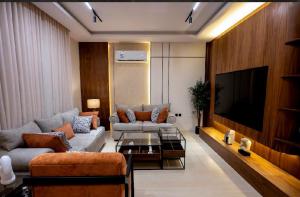 a living room with a couch and a tv at شقة مودرن مع جاكوزي خاص دخول ذاتي in Riyadh