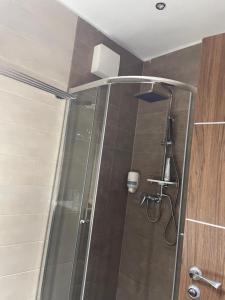 a shower with a glass door in a bathroom at Nice Wellness Apartman in Siófok +8 photos