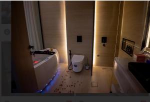 a bathroom with a toilet and a tub with blood on the floor at شقة مودرن مع جاكوزي خاص دخول ذاتي in Riyadh +4 photos