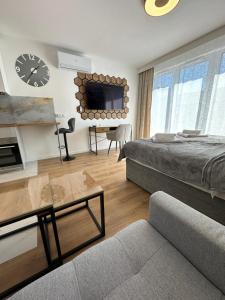 a bedroom with a bed and a couch and a clock at LUXURY Portovo in Gdańsk