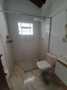 a bathroom with a toilet and a glass shower at Recanto do Gigante Adormecido in Joanópolis +30 photos