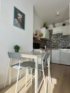a kitchen with a white table and chairs at Apartament z KLIMATYZACJĄ - ul Plebiscytowa 19 - darmowy parking in Opole