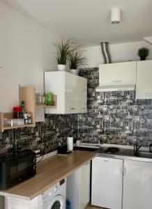 a kitchen with white cabinets and a patterned wall at Apartament z KLIMATYZACJĄ - ul Plebiscytowa 19 - darmowy parking in Opole