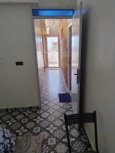 a hallway with a tile floor and a chair at Tamraght samba 3 in Tamraght Ou Fella