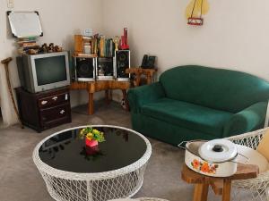 a living room with a green couch and a tv at Chichicoland in Tena