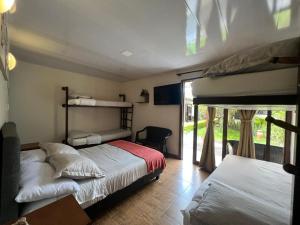 a bedroom with two bunk beds and a window at Posada Tierra Viva - Villa de Leyva in Villa de Leyva
