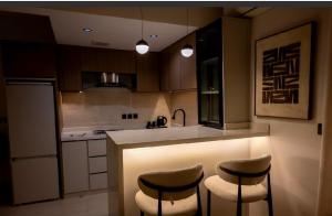 a kitchen with two bar stools and a counter top at شقة مودرن مع جاكوزي خاص دخول ذاتي in Riyadh