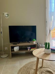 a living room with a large flat screen tv at Abri 82 in Picauville