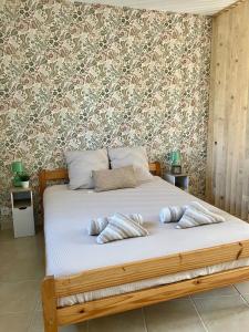 a bedroom with a bed with two pillows on it at Abri 82 in Picauville