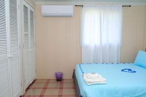 a bedroom with a blue bed and a window at Nestled Vacation Home in St Johns Antigua in Saint Johnʼs