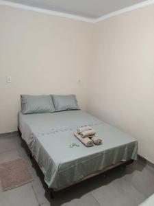 a bed with two phones on it in a room at hospedagem da rosa in Morretes