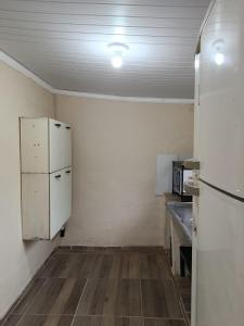 an empty kitchen with a refrigerator and a counter at hospedagem da rosa in Morretes +9 photos