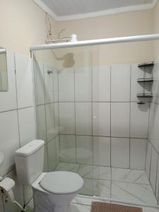 a white bathroom with a shower and a toilet at hospedagem da rosa in Morretes