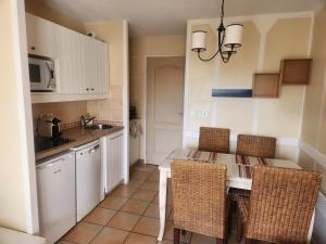 a kitchen with a table and chairs and a microwave at Residence de bordaberry in Urrugne
