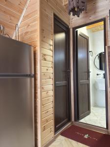 a kitchen with a refrigerator and a door to a bathroom at Bondo'S Cottage in Kobuleti +89 photos
