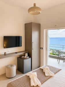 a room with a bed with a flat screen tv at Nostos Palase in Dhërmi