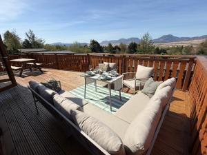 a couch sitting on a deck with a table at Beautifully Restored Log Cabin in Trawsfynydd