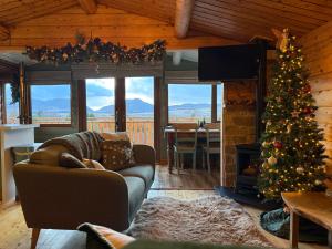 a living room with a christmas tree and a fireplace at Beautifully Restored Log Cabin in Trawsfynydd