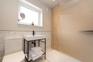 a bathroom with a toilet and a sink and a window at Murray Cottage in Gardenstown +27 photos