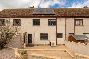 a house with solar panels on the roof at Murray Cottage in Gardenstown