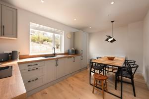 a kitchen with a table and chairs and a window at Murray Cottage in Gardenstown