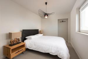 a bedroom with a white bed and a window at Murray Cottage in Gardenstown
