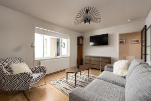 a living room with a couch and a chair at Murray Cottage in Gardenstown