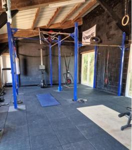 a gym with blue poles in a room at pavillon en pleine nature in Brains-sur-Gée