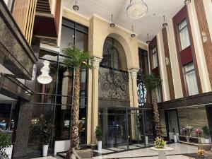 a lobby with palm trees in a building at Art Royal in Tashkent