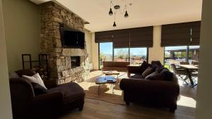 a living room with couches and a stone fireplace at Veles Luxury House in Hisarya +29 photos
