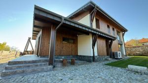 a house with a porch with a bench in front of it at Veles Luxury House in Hisarya