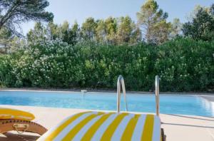 a swimming pool with a yellow and white chair next to it at Chalet Le Luc - Casa Zenitude in Le Luc +14 photos