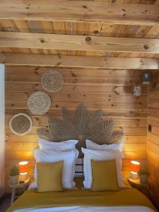a bedroom with a wooden wall and a bed with pillows at Chalet Le Luc - Casa Zenitude in Le Luc