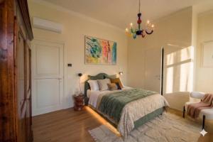 a bedroom with a bed and a chandelier at Villa alle Mura in Lucca