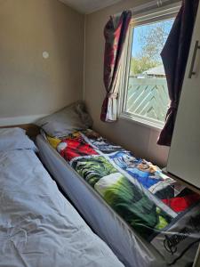 a bed in a small room with a window at PMH rental in Saint Osyth +7 photos