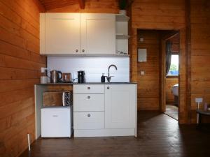 a kitchen with white appliances in a wooden cabin at Alpaca My Bags! at Andean Alpacas in Mullingar +16 photos